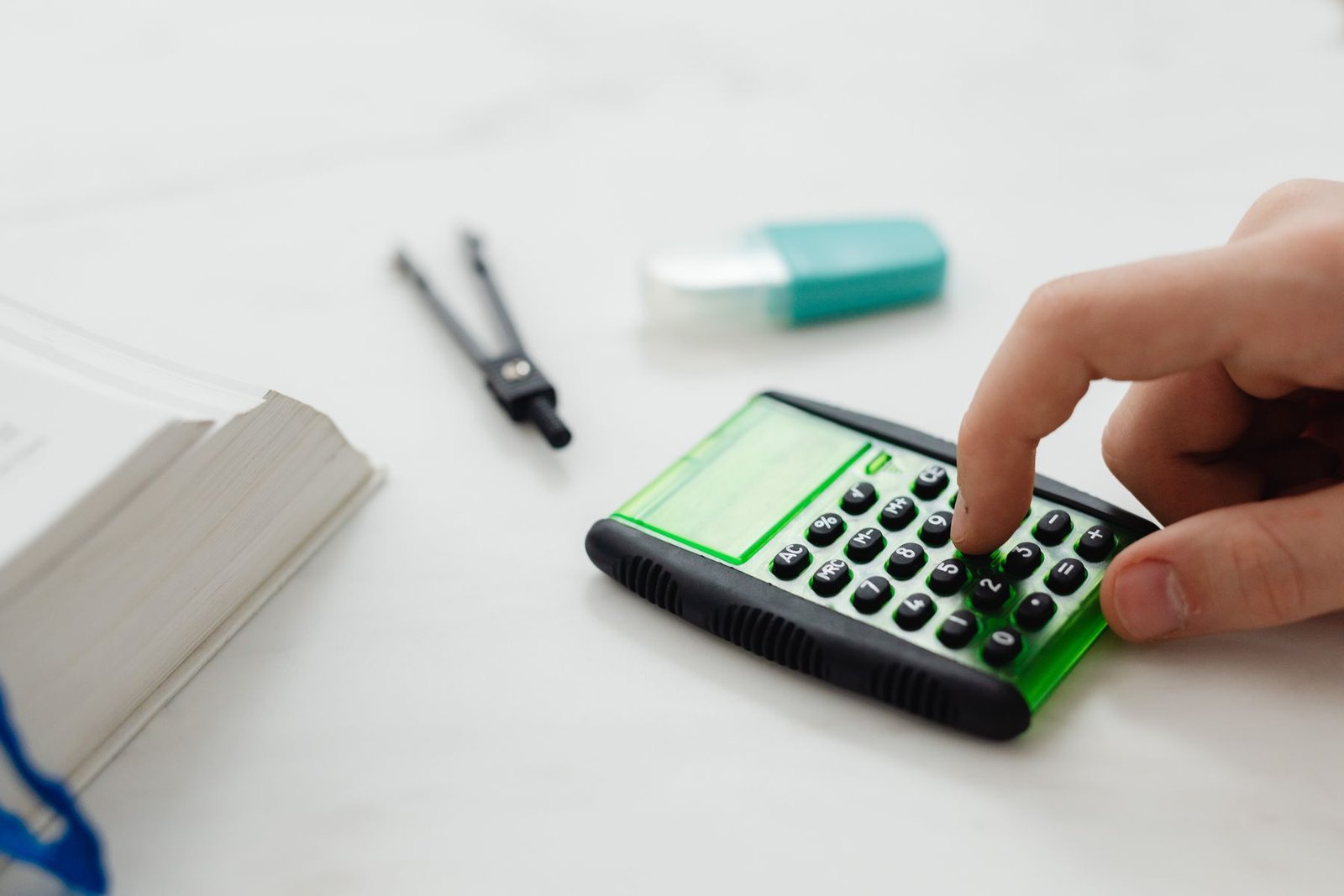 Detalle de una mano usando una calculadora para revisar cifras contables