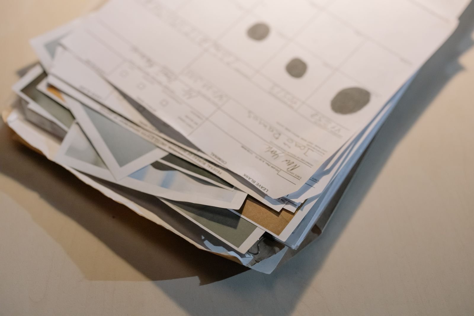 Pila de papeles y documentos variados sobre la superficie de un escritorio