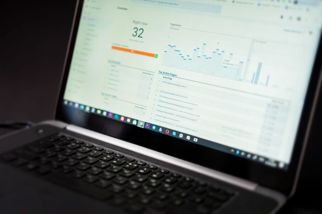 Laptop mostrando un panel de analisis con datos y graficas en una oficina